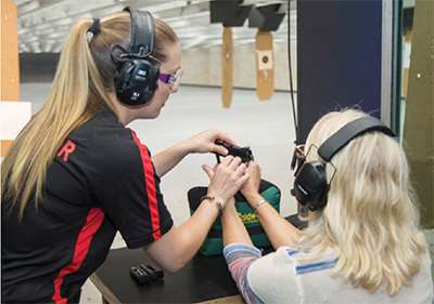 Female instructor with female student at gun range